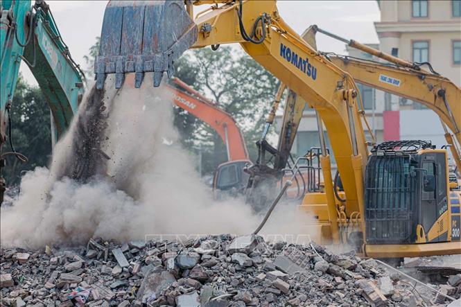 Máy xúc phá dỡ phần nền bê tông còn lại tại khu vực công trình. Ảnh: Phạm Tuấn Anh - TTXVN