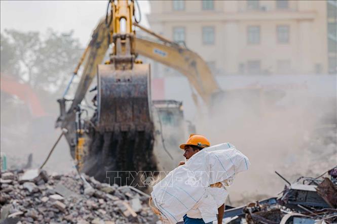 Các công nhân làm việc giữa khói bụi và tiếng máy móc tại đại công trường giải phóng mặt bằng. Ảnh: Phạm Tuấn Anh - TTXVN

