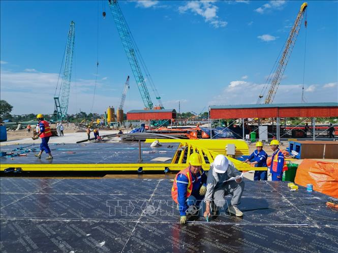 Công trường thi công dự án cầu Tứ Liên trên sông Hồng đang được triển khai với nhiều hạng mục nền móng, tập kết máy móc và vật liệu phục vụ thi công. Ảnh: Lê Đông - TTXVN