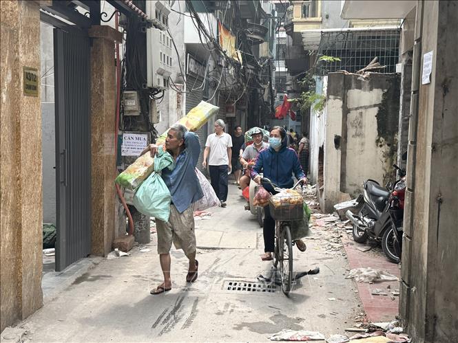 Người dân di chuyển đồ sau khi đãn bàn giao mặt bằng cho chính quyền địa phương. Ảnh: Quốc Lũy - TTXVN
