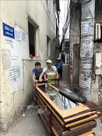 Người dân di chuyển đồ để bàn giao mặt bằng cho chính quyền địa phương. Ảnh: Quốc Lũy - TTXVN