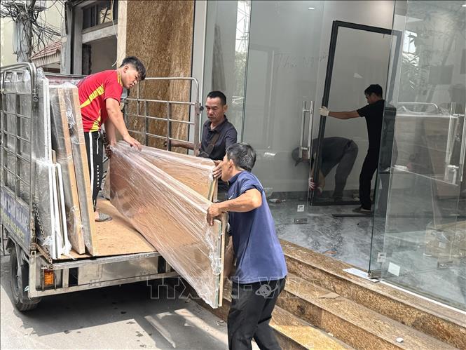 Hộ dân trong ngách 12/39 phố Chính Kinh, phường Thanh Xuân di chuyển đồ đạc, bàn giao mặt bằng cho chính quyền địa phương. Ảnh: Quốc Lũy - TTXVN