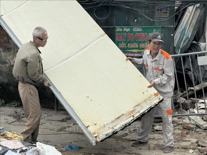 Hộ gia đình tiến hành tháo dỡ những phần còn lại để bàn giao mặt bằng cho chính quyền địa phương. Ảnh: Quốc Lũy - TTXVN