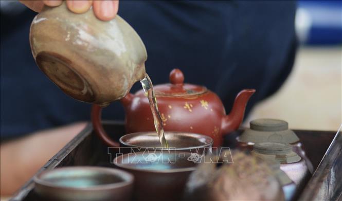 Nghệ nhân rót trà sen mời khách. Ảnh: Văn Dũng-TTXVN