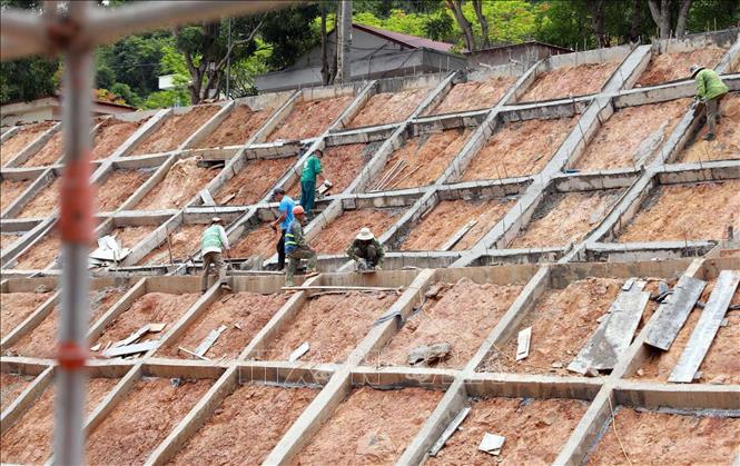 Thi công hệ thống kè chống sạt lở khu vực phía sau dự án. Ảnh: Quý Trung – TTXVN