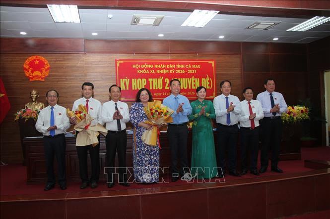 Chủ tịch HĐND tỉnh Cà Mau Phạm Văn Thiều tặng hoa chúc mừng các Ủy viên UBND tỉnh vừa trúng cử. Ảnh: Chanh Đa-TTXVN