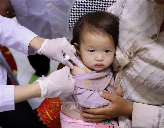 Bé Thào Thị Linh Tây 13 tháng tuổi thực hiện tiêm vacxin tại Trạm Y tế xã Tà Xùa. Ảnh: Trọng Đạt-TTXVN