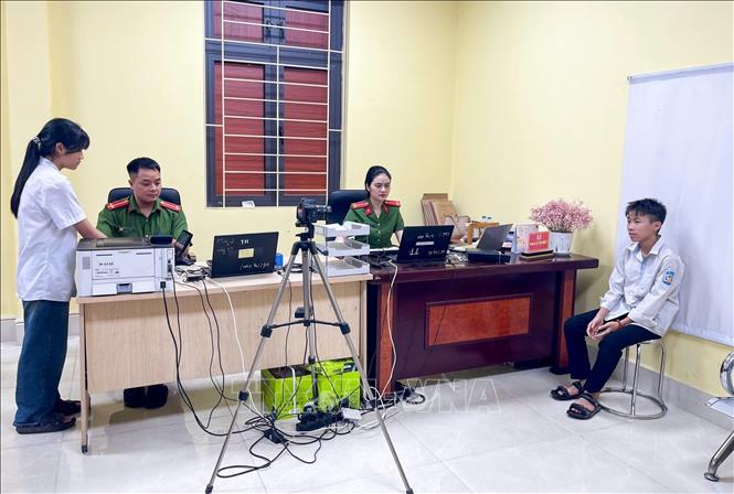Nữ Công an phường Thuận Thành làm CCCD cho học sinh. Ảnh: Danh Lam -TTXVN 