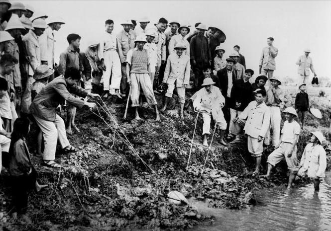 Sau khi miền Bắc hoàn toàn giải phóng, Chủ tịch Hồ Chí Minh cùng Trung ương Đảng tập trung lãnh đạo củng cố miền Bắc về mọi mặt, trước hết phải khôi phục và nâng cao sản xuất nông nghiệp. Người cho rằng, nông nghiệp phải là mặt trận hàng đầu. Trong ảnh: Chủ tịch Hồ Chí Minh tham gia tát nước chống hạn cùng nông dân xã Đại Thanh, Hà Đông (nay là Hà Nội), ngày 12/1/1958. Ảnh: Tư liệu TTXVN