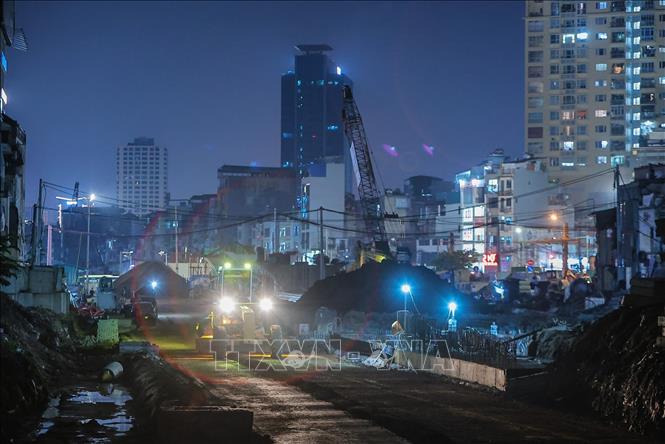 Công nhân cùng nhiều thiết bị, máy móc khẩn trương thi công các hạng mục cầu vượt và nền đường trong điều kiện làm việc 3 ca, 4 kíp liên tục. Ảnh: Lê Đông - TTXVN