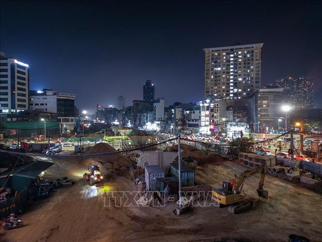 Nhiều thiết bị máy móc cỡ lớn hoạt động liên tục trong đêm để phục vụ thi công đường tuyến Vành đai 1. Ảnh: Lê Đông - TTXVN