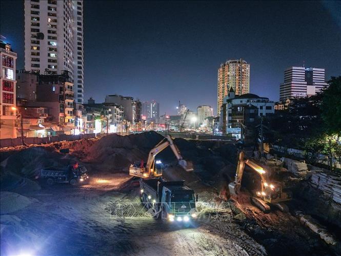 Nhiều thiết bị máy móc cỡ lớn hoạt động liên tục trong đêm để phục vụ thi công đường tuyến Vành đai 1. Ảnh: Lê Đông - TTXVN