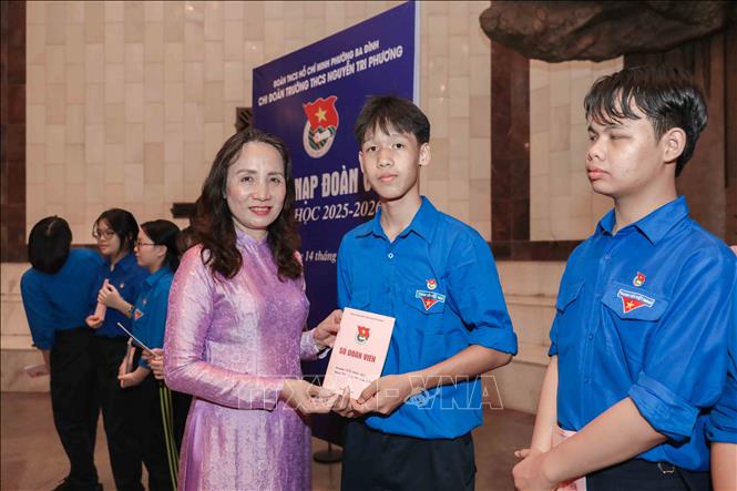 Tại Bảo tàng Hồ Chí Minh, bà Nguyễn Thị Thu Thủy, Hiệu trưởng Trường THCS Nguyễn Tri Phương, trao Sổ Đoàn viên, chúc mừng các đội viên tiêu biểu của trường chính thức đứng vào hàng ngũ Đoàn. Ảnh: Phan Phương – TTXVN