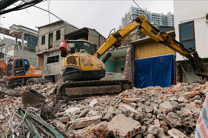 Máy xúc phá dỡ một công trình nằm trong diện giải phóng mặt bằng trên phố Lĩnh Nam. Ảnh: Phạm Tuấn Anh - TTXVN