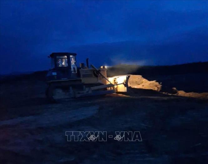 Các phương tiện, máy móc thi công trên cao tốc Cam Lộ - La Sơn vào ban đêm. Ảnh: TTXVN phát