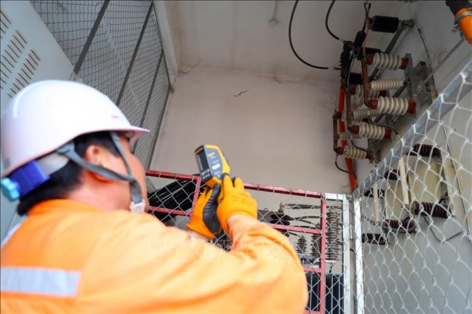 Cán bộ điện lực Hà Tĩnh sử dụng thiết bị đo nhiệt để kiểm tra hệ thống điện tại khu dân cư. Ảnh: Hữu Quyết - TTXVN