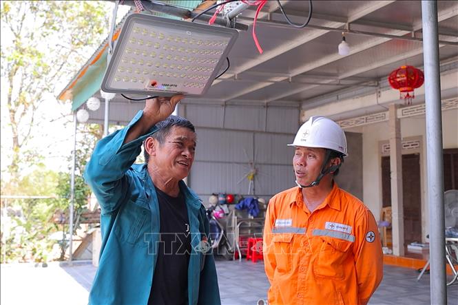 Cán bộ điện lực Hà Tĩnh tuyên truyền cho người dân sử dụng các thiết bị năng lượng mặt trời để tiết kiệm điện ‎. Ảnh: Hữu Quyết - TTXVN