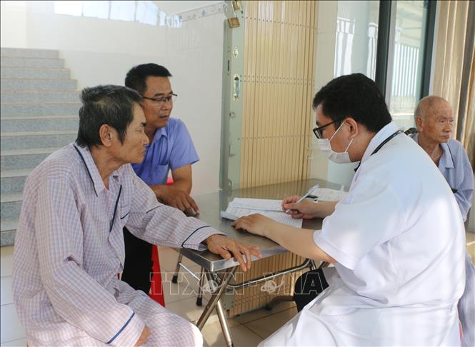 Đội ngũ nhân viên y tế cùng tình nguyện viên hướng dẫn người dân trong quá trình thăm khám. Ảnh: Tuấn Kiệt – TTXVN