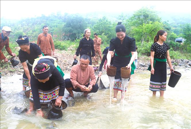 Người dân Ơ Đu trong bản Văng Môn cùng nhau mang các vật dụng sinh hoạt hằng ngày ra suối thiêng Nậm Ngân để thực hiện nghi thức “rửa xui” trong ngày lễ đón tiếng sấm đầu năm. Ảnh: Xuân Tiến - TTXVN 