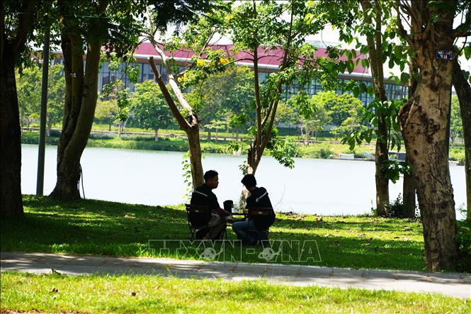 Người dân đến công viên ở bờ Bắc sông Hương, phường Phú Xuân, thành phố Huế để hóng mát, tránh nắng nóng. Ảnh: Nguyên Lý- TTXVN