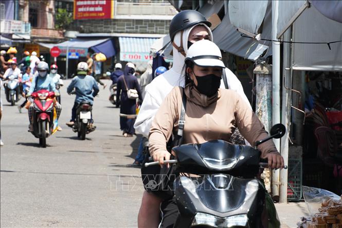 Người dân vất vả đi lại trong điều kiện nắng nóng, ở đường Chương Dương, phường Phú Xuân, thành phố Huế. Ảnh: Nguyên Lý- TTXVN