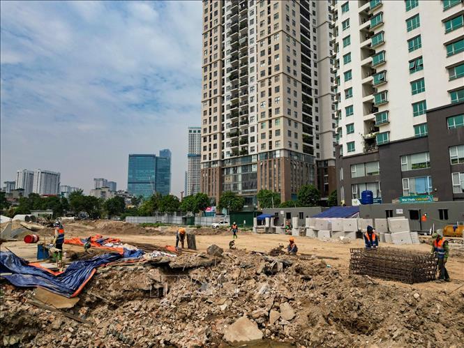 Công nhân và máy móc được huy động để thi công hạng mục hạ tầng kỹ thuật trên tuyến đường Vành đai 2,5. Ảnh: Lê Đông - TTXVN