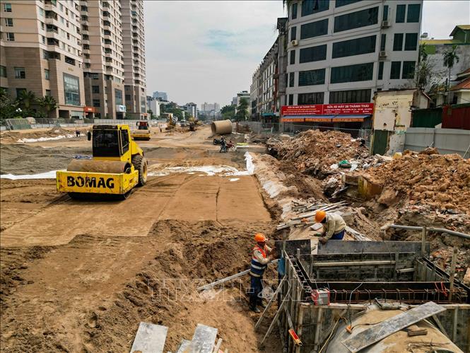 Công nhân và máy móc được huy động để thi công hạng mục hạ tầng kỹ thuật trên tuyến đường Vành đai 2,5. Ảnh: Lê Đông - TTXVN