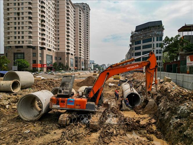 Đơn vị thi công đang triển khai lắp đặt hệ thống cống thoát nước trên tuyến dự án Vành đai 2,5. Ảnh: Lê Đông - TTXVN