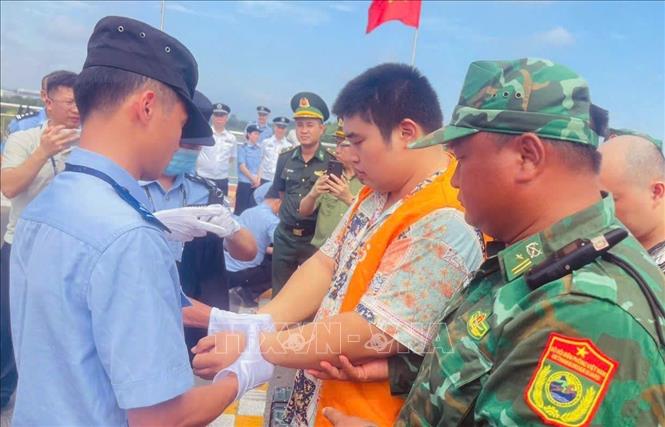 Trao trả các công dân Trung Quốc vi phạm pháp luật Việt Nam cho cơ quan chức năng Trung Quốc. Ảnh: TTXVN phát