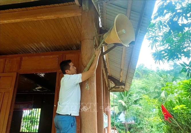 Trưởng bản Na Ngân, anh Lương Văn Ủn lắp đặt loa phóng thanh tại Nhà văn hóa cộng đồng của bản. Ảnh: Xuân Tiến - TTXVN 