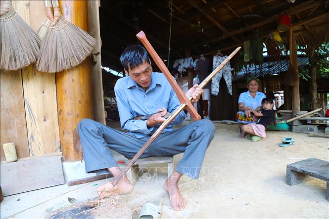  Đàn ông trong bản Na Ngân chế tác cung nỏ để tham gia hội diễn thể thao, thi thố tài năng trong dịp bản làng tổ chức vui hội. Ảnh: Xuân Tiến - TTXVN 
