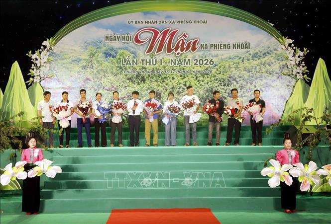 Lãnh đạo xã Phiêng Khoài tặng hoa tri ân người trồng mận trên địa bàn xã. Ảnh: Quang Quyết - TTXVN