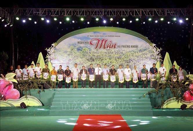Ban Tổ chức trao cờ lưu niệm cho đại diện các bản, đơn vị trường học, hợp tác xã tham gia Ngày hội. Ảnh: Quang Quyết - TTXVN