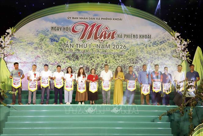 Ban Tổ chức trao cờ lưu niệm cho đại diện các bản, đơn vị trường học, hợp tác xã tham gia Ngày hội. Ảnh: Quang Quyết - TTXVN