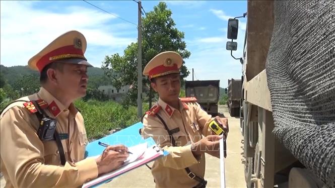 Lực lượng cảnh sát giao thông, Công an tỉnh Thanh Hóa lập biên bản xử lý phương tiện vi phạm chở quá khổ quá tải. Ảnh: Nguyễn Nam-TTXVN