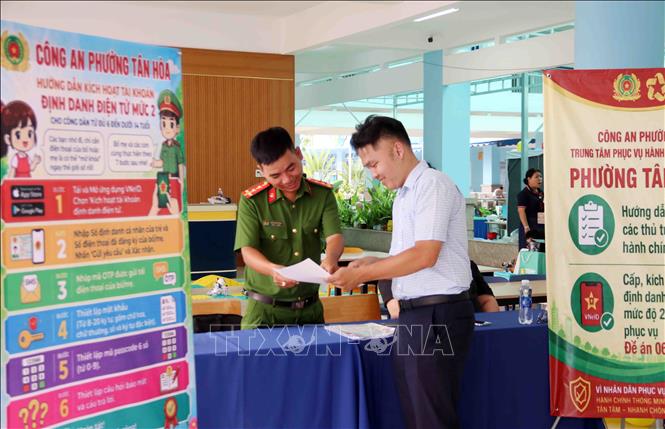 Lực lượng công an cơ sở tham gia hoạt động giới thiệu, hướng dẫn chuyển đổi số cho người dân. Ảnh: Xuân Khu - TTXVN