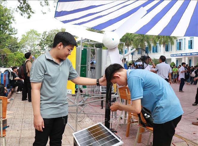 Sinh viên nghiên cứu, chế tạp lắp đặt hệ thống điện gió kết hợp năng lượng mặt trời. Ảnh: Phan Sáu - TTXVN