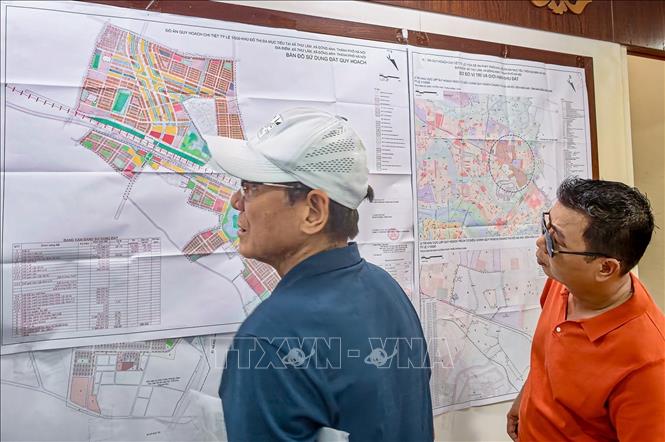Người dân phường Hồng Hà tìm hiểu quy hoạch, vị trí các lô đất tại khu tái định cư xã Thư Lâm trước khi ổn định nơi ở mới. Ảnh: Trung Nguyên - TTXVN