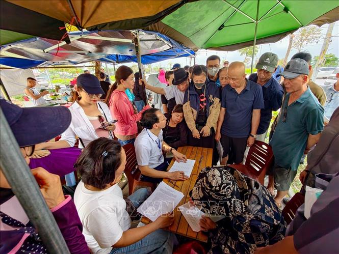 Người dân phường Hồng Hà thực hiện các thủ tục ký nhận lô đất, thửa đất tại khu tái định cư xã Thư Lâm. Ảnh: Trung Nguyên - TTXVN