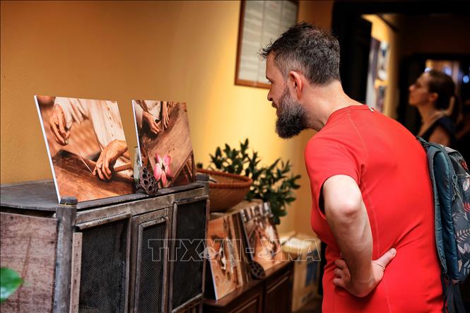 Du khách tham quan khu trưng bày hình ảnh về nghề làm tơ sen của Nghệ nhân Ưu tú Phan Thị Thuận trong khuôn khổ sự kiện “Hương sen lối cũ – Mùa 3”. Ảnh: Phạm Tuấn Anh - TTXVN