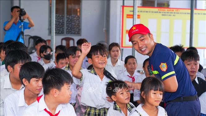 Học sinh xã Phước Vinh hào hứng tham gia trả lời câu hỏi tìm hiểu kỹ năng phòng tránh tai nạn thương tích. Ảnh: Minh Phú - TTXVN 