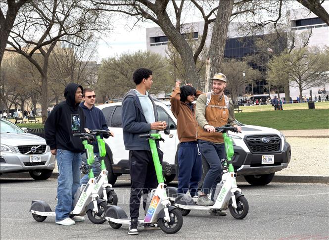 Một nhóm thanh niên đi xe Scooter điện tại Quảng trường Quốc gia ở thủ đô Washington D.C. Ảnh: Ngọc Quang – PV TTXVN tại Mỹ