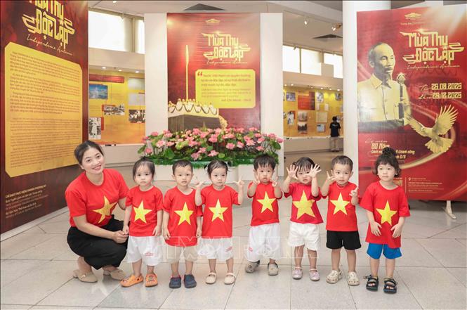 Các bé mẫu giáo mặc đồng phục cờ đỏ sao vàng đáng yêu, rạng rỡ chụp ảnh lưu niệm tại không gian trưng bày “Mùa thu Độc lập”. Ảnh: Phan Phương – TTXVN