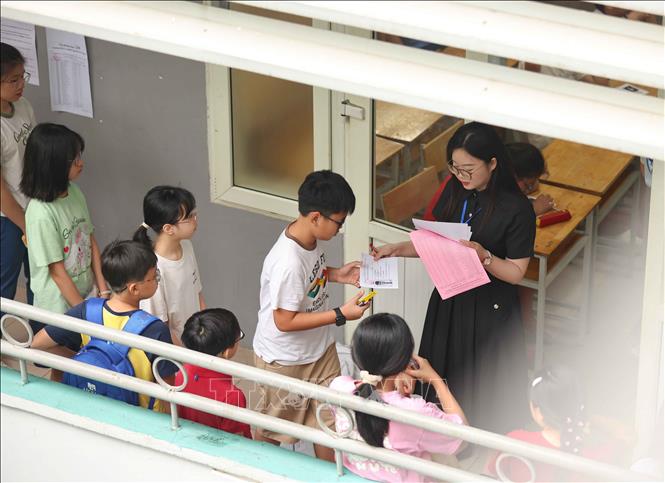 Gọi học sinh vào phòng thi và ngồi theo số báo danh. Ảnh: Thanh Tùng - TTXVN