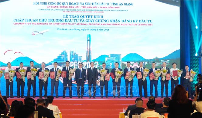 Lãnh đạo tỉnh An Giang trao Quyết định chấp thuận chủ trương đầu tư và Giấy chứng nhận đăng ký đầu tư cho các nhà đầu tư. Ảnh: Văn Sĩ - TTXVN 
