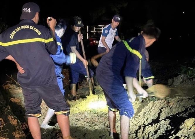 Lực lượng công an dọn dẹp đất đá sạt lở tại các tuyến đường. Ảnh: TTXVN phát