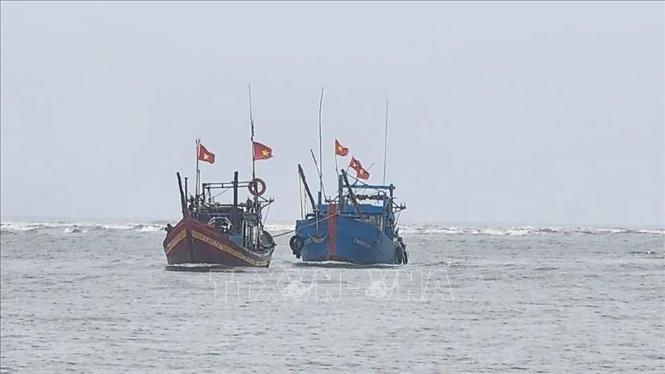 Lai dắt tàu bị cuốn trôi vào bờ. Ảnh: TTXVN phát 