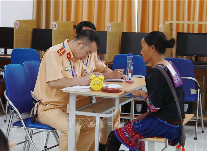 Cán bộ sát hạch phần lý thuyết hỏi vấn đáp thí sinh (hỏi – và trả lời trực tiếp) thay vì làm bài thi trên máy dành cho người không biết chữ phổ thông. Ảnh: Quý Trung – TTXVN
