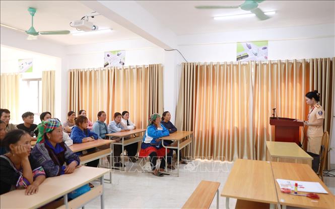 Cán bộ Đội sát hạch lái xe cơ giới đường bộ, Công an tỉnh Lai Châu hướng dẫn người dân tham gia sát hạch giấy phép lái xe về những tình huống tham gia giao thông mất an toàn đã xảy ra trên địa bàn. Ảnh: Quý Trung - TTXVN