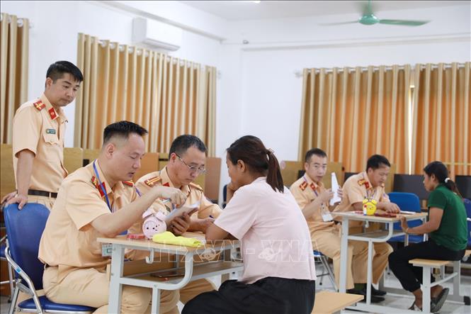 Cán bộ sát hạch phần lý thuyết hỏi vấn đáp thí sinh (hỏi – và trả lời trực tiếp) thay vì làm bài thi trên máy. Ảnh: Quý Trung – TTXVN